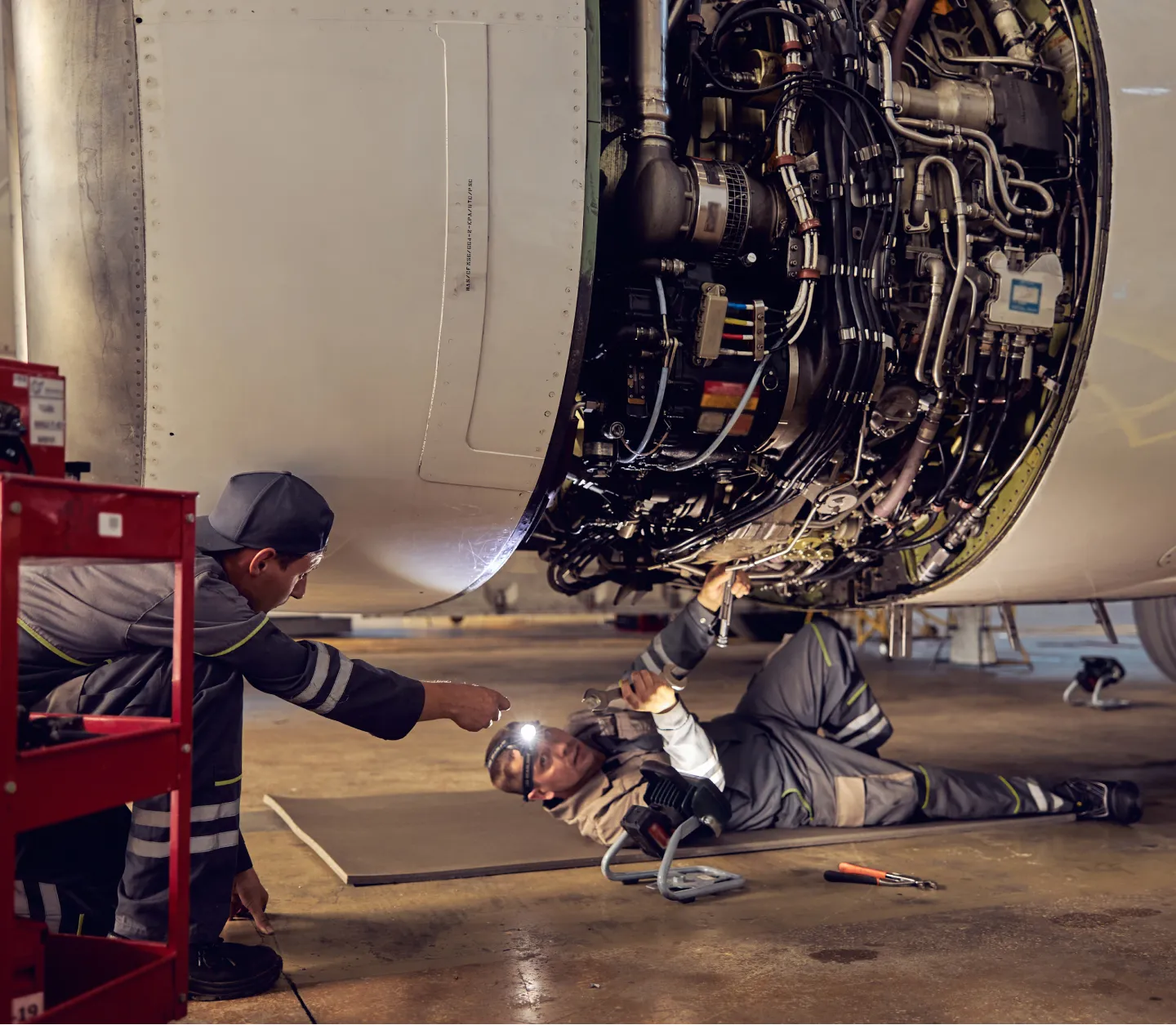 Two aviation mechanics working on an engine