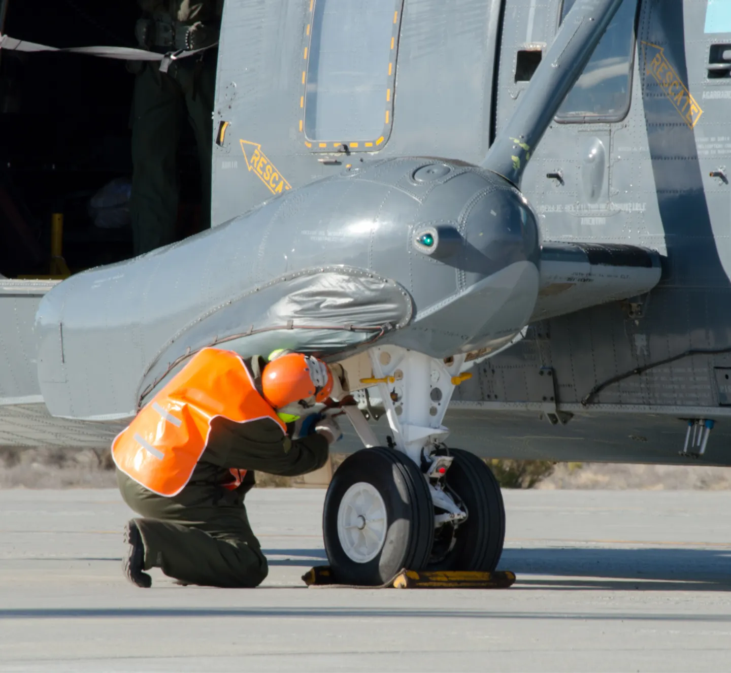 An aircraft mechanic working on the exterior of a military aircraft